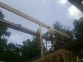 Carpenter setting a ridge beam over a new addition frame — Ice Dam Removal by Roofing Brothers in Ramona