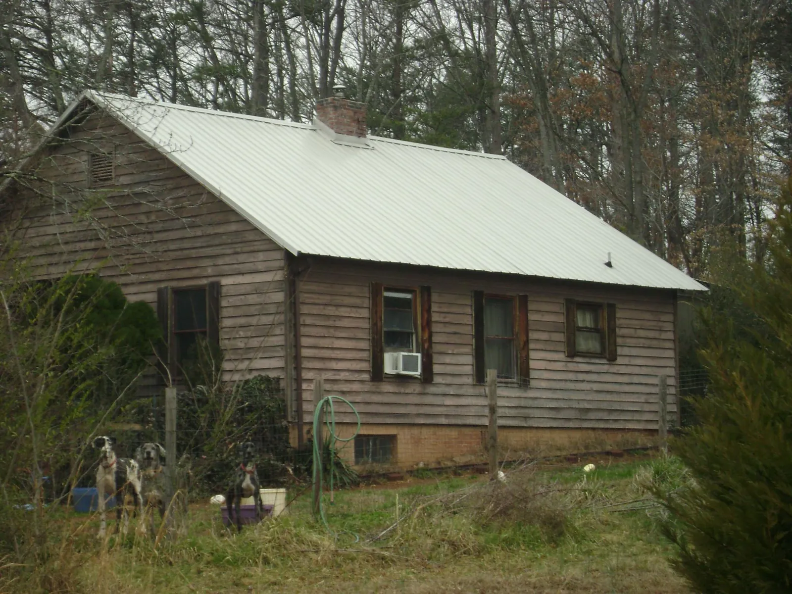 White metal roof on an old wood sided farmhouse, from a Metal Roof Installation job in Ramona